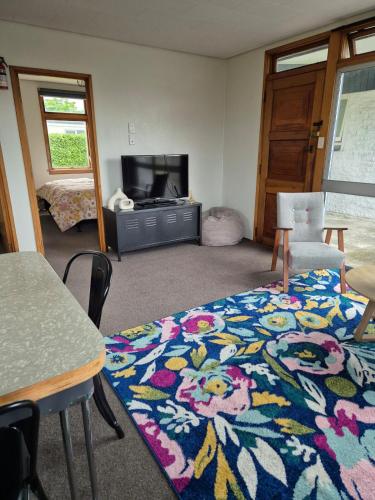 a living room with a colorful rug on the floor at McKerrow St in Te Anau