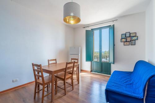 a dining room with a table and a blue couch at Casa Patrizia in centro a Marzamemi in Marzamemi
