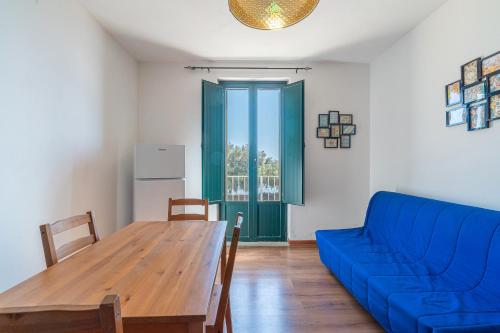 a living room with a blue couch and a wooden table at Casa Patrizia in centro a Marzamemi in Marzamemi