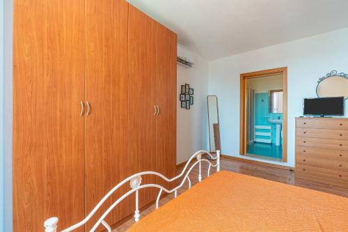 a bedroom with wooden cabinets and a bed and a dresser at Casa Patrizia in centro a Marzamemi in Marzamemi
