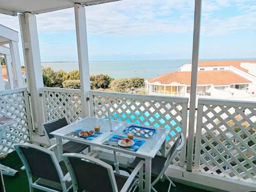 - une table sur un balcon avec vue sur l'océan dans l'établissement Les Terrasses de Fort Boyard, à Fouras