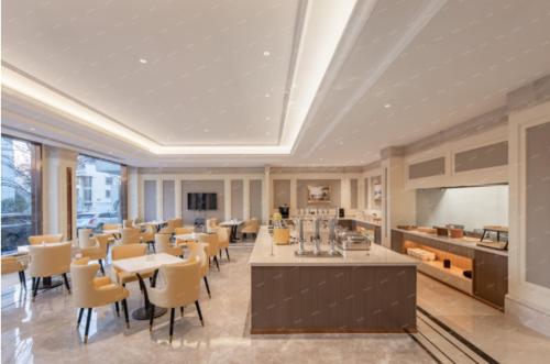 a dining room with tables and chairs in a building at Vienna Hotel Yiwu Heart Branch in Yiwu