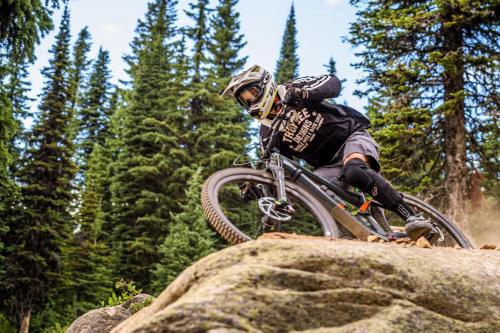 a person on a bike jumping over a rock at Winter Escape On Perfection - Ski In Out, Pool & Hot Tub in Big White