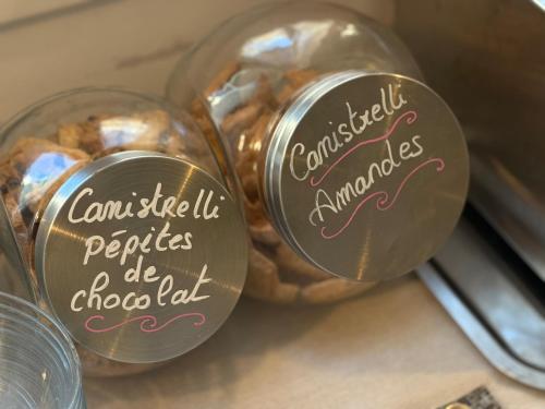 Un grupo de frascos de comida con escritura en ellos. en Hôtel du Nord, en Corte