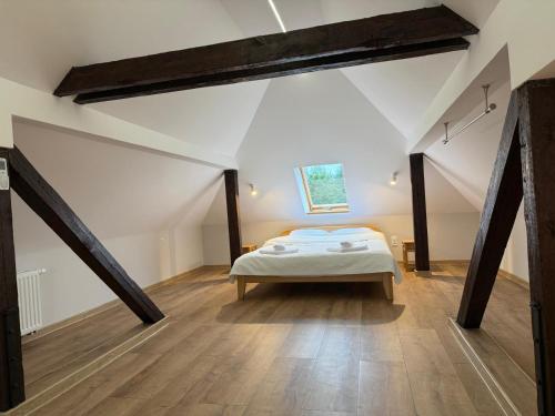 a bedroom with a bed in a attic at Kuźnia-Grodno in Krzywa Wieś
