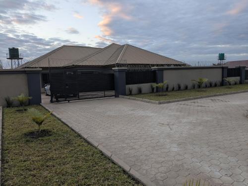 Un edificio con techo y un banco al frente. en Gabstel Apartments, en Kitwe