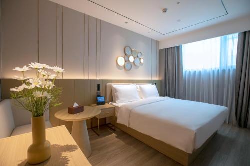 Ένα ή περισσότερα κρεβάτια σε δωμάτιο στο Orange Beijing Wukesong Shijingshan Wanda Plaza Hotel