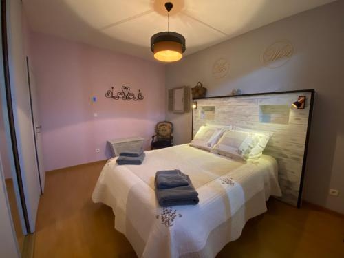 ViolèsにあるTrès beau mas provençal entièrement rénové Piscine & SPA entre Dentelles & Ventouxのタオルが敷かれた大きな白いベッドのある寝室
