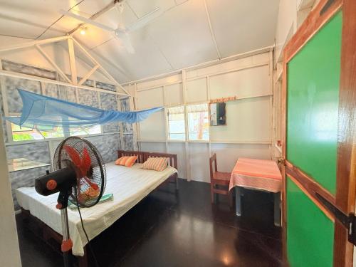 Una habitación con dos camas y un ventilador. en Lahiru Place, en Arugam Bay