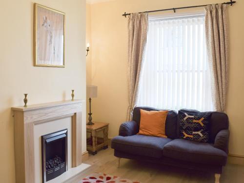 a living room with a couch and a fireplace at Gable Cottage in Keswick