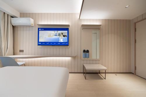 a hospital room with a tv on the wall at Hanting Hotel Beijing Normal University Jishuitan in Beijing