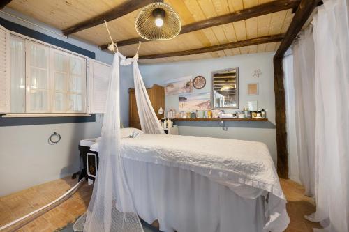 un dormitorio con una cama con mosquitera en Marine House Spa, en Tavira