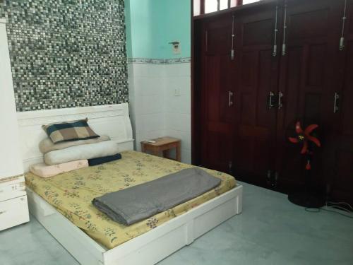 1 dormitorio con 1 cama y algunos armarios de madera en Phúc Long Hiwinwin, en Chợ Phước Hải
