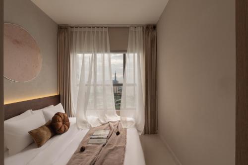 a bedroom with a bed with a window at DingD0ng Suites - The Sun Avenue - Free Pool & Gym in Ho Chi Minh City