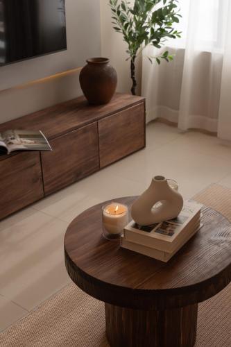 a living room with a table with a candle on it at DingD0ng Suites - The Sun Avenue - Free Pool & Gym in Ho Chi Minh City