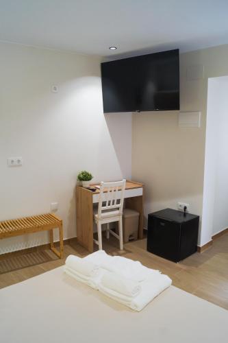 a room with a bed with a chair and a desk at Alojamientos Dunas del Alba in Chipiona