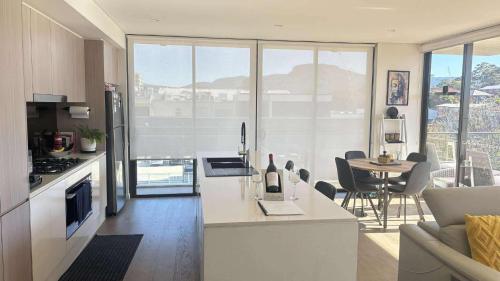 a kitchen and living room with a table and chairs at beach pad in Wollongong