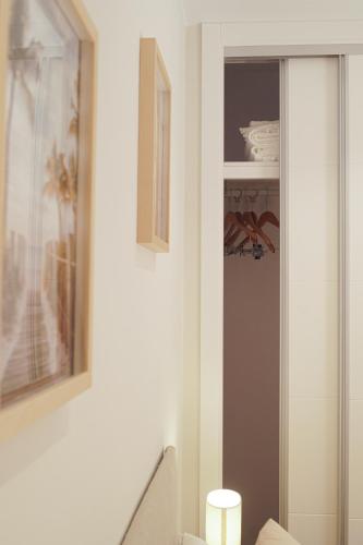 a bathroom with a toilet and a shelf at Alojamientos Dunas del Alba in Chipiona