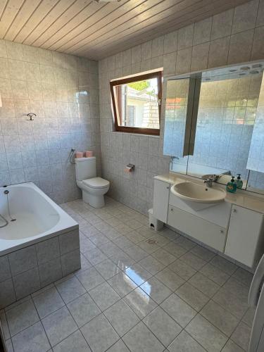 a bathroom with a tub and a sink and a toilet at Villa Sunny Side in Ždrelac