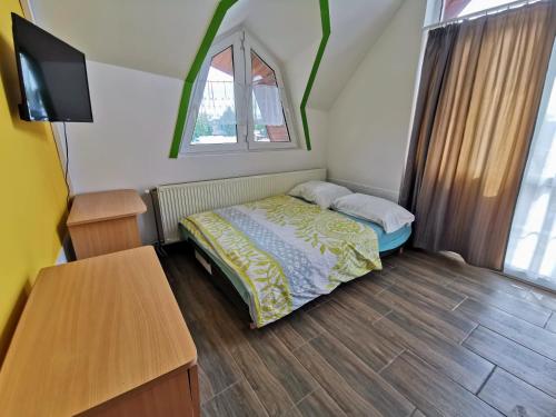 a small bedroom with a bed and a table at Napospart 33 in Balatonlelle