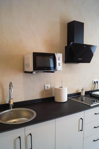 a kitchen with a sink and a microwave at Alojamientos Dunas del Alba in Chipiona