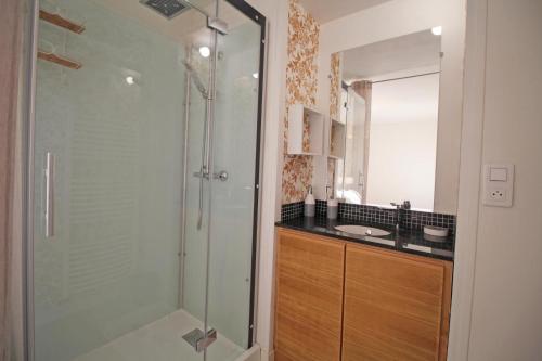 a bathroom with a glass shower and a sink at La maison d'eugenie in Jourgnac
