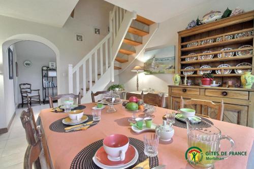 a dining room table with a pink table cloth at Le verger in Pluneret