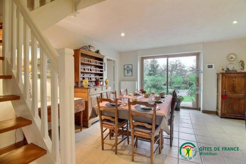 a dining room with a table and some chairs at Le verger in Pluneret