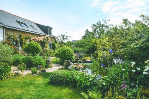 a garden in front of a house with flowers at Le verger in Pluneret