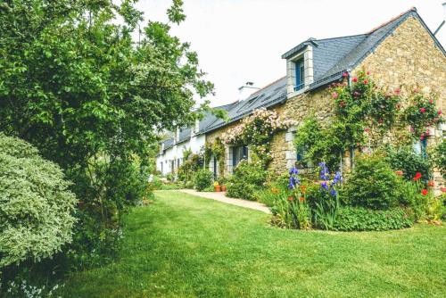 a house with a garden with flowers in the yard at Le verger in Pluneret