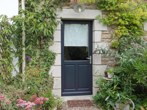 a blue door on a brick house with plants at Le verger in Pluneret