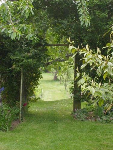 a garden with an archway in the grass at Le verger in Pluneret