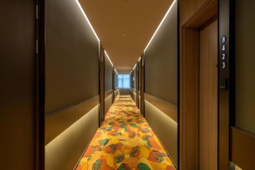 a hallway with a carpeted aisle with lights at Orange Hotel Beijing Wukesong Dacheng Road in Beijing