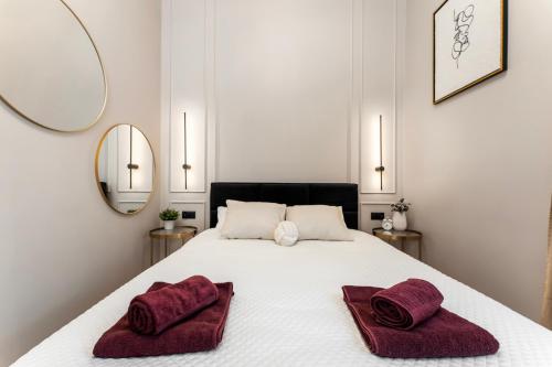 a bedroom with a white bed with two towels on it at LIFESTYLE Apartments in Bochnia