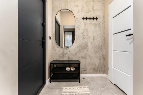 a hallway with a mirror and a black door at LIFESTYLE Apartments in Bochnia
