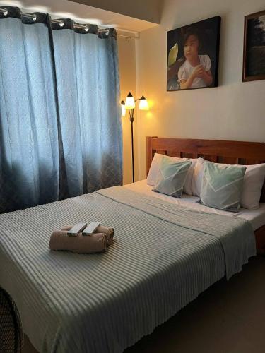 une chambre avec un lit avec deux serviettes dessus dans l'établissement Condo Studio at Baguio Fog Fern Transient Home, à Baguio