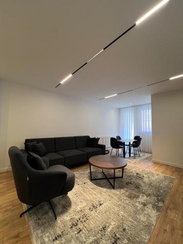 プリシュティナにあるPristina Luxury Apartments 21の黒いソファとテーブルのあるリビングルーム