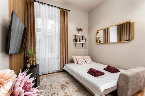 a small bedroom with a bed and a large window at LIFESTYLE Apartments in Bochnia