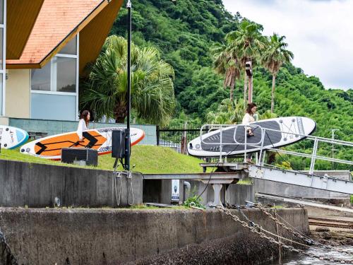 a couple of people with surfboards on a ramp at Calm Lanai Harbor in Nichinan