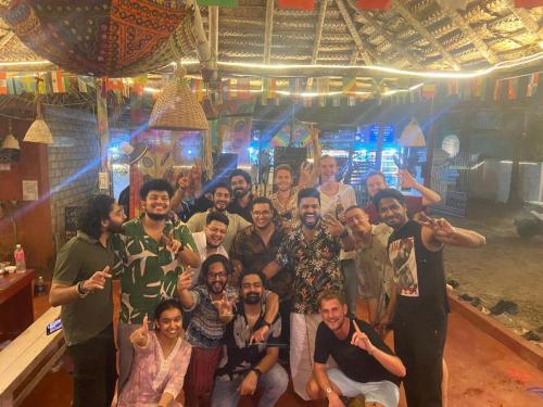 a group of people posing for a picture in a bar at HostelExp, Varkala - A Beach Town Hostel in Varkala