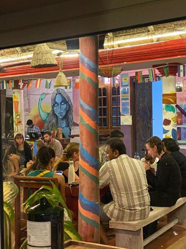a group of people sitting at a table in a restaurant at HostelExp, Varkala - A Beach Town Hostel in Varkala