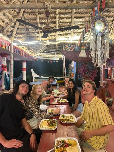 a group of people sitting at a table eating food at HostelExp, Varkala - A Beach Town Hostel in Varkala