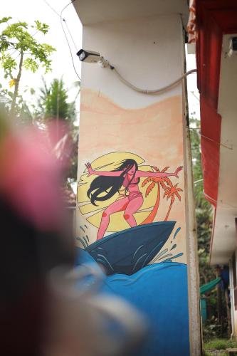 a wall with a painting of a girl on it at HostelExp, Varkala - A Beach Town Hostel in Varkala