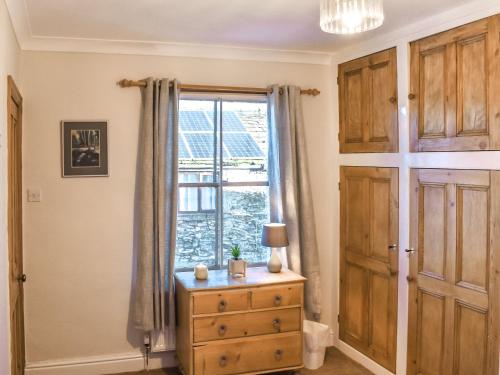 a bedroom with a dresser and a window at Clouds End in Grassington