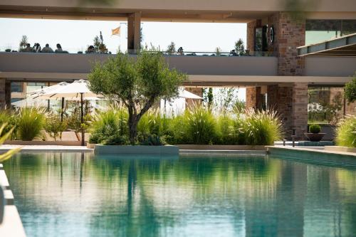 a swimming pool in front of a house at Royal Pearl Island Chios Hotel and Spa in Chios