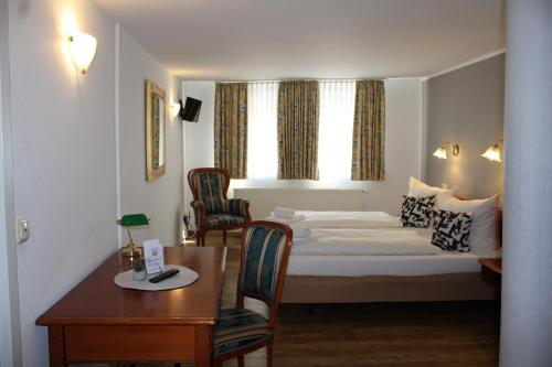 a hotel room with a bed and a table and chairs at Hotel Eisenbahn in Karlstadt