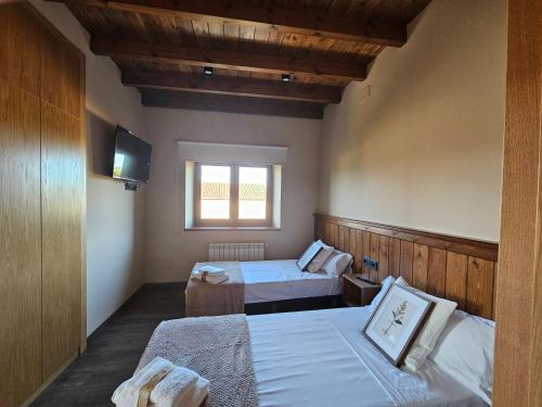 a hotel room with two beds and a television at Villanueva 5 in Luces
