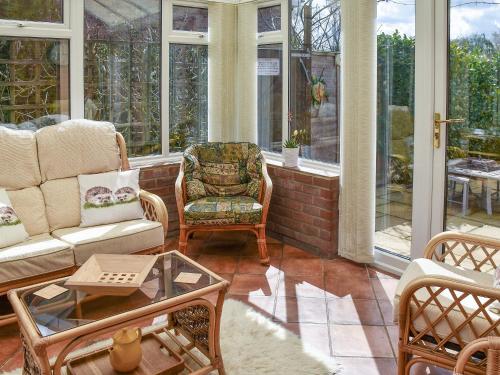a screened in porch with a couch and chairs at Meadow View in Hockering