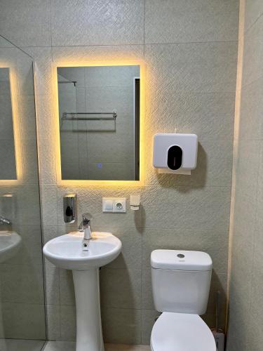 a bathroom with a sink and a toilet and a mirror at Sataplia Inn in Tskaltubo