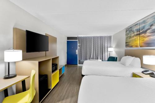 a hotel room with two beds and a flat screen tv at Days Inn by Wyndham Seneca-Clemson in Seneca